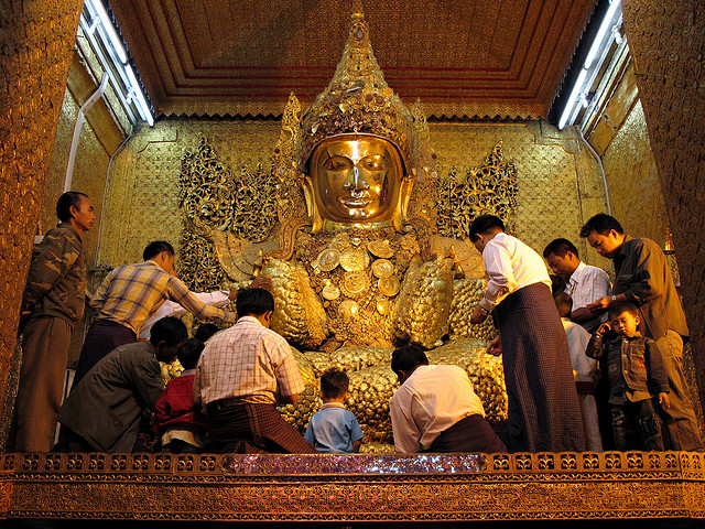 Les fidèles prient devant la statue de Bouddha à l'intérieur de la pagode