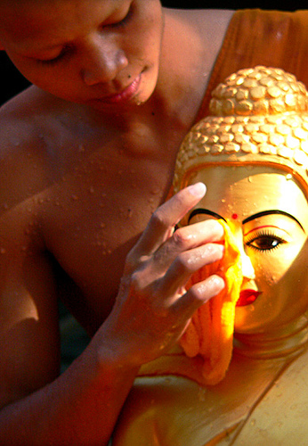 Les fidèles nettoient les statues de Bouddha avec de l'eau parfumée